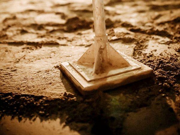 Sand wird mit dem Presser platt gemacht