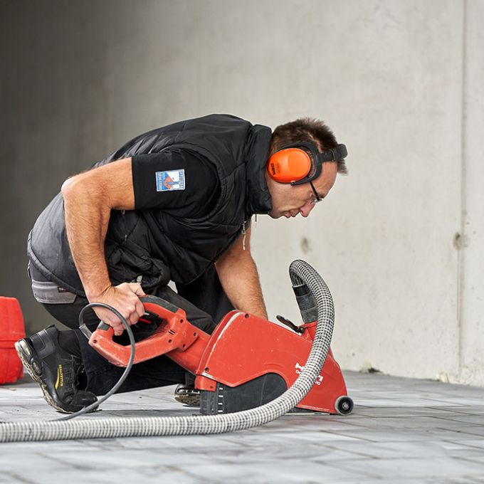 Handwerker schneidet keramische Rüttelbeläge mit einer Bodensäge