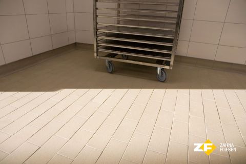 Keramischer Bodenbelag mit Transportwagen in einer Großbäckerei